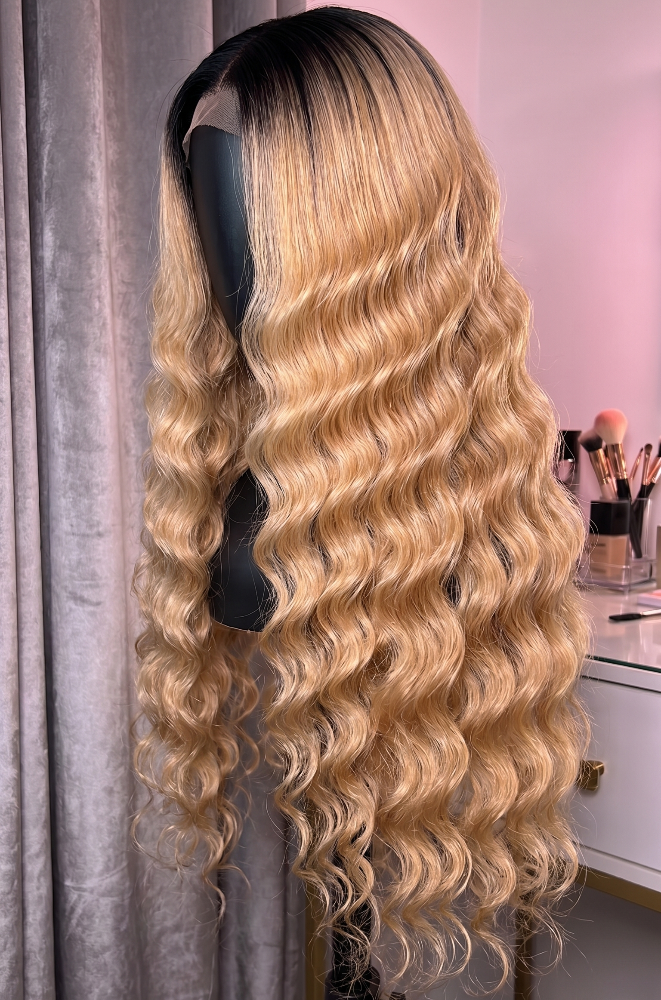 Deep Wave Brazilian Remy Human Hair wig with pre-plucked 4/613 blonde extensions by Celebrity Hair & Beauty, styled with wavy curls.